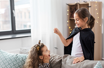 Image showing girls in halloween costumes playing with spider