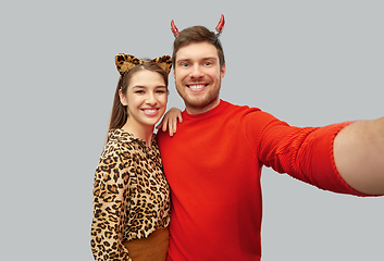 Image showing happy couple in halloween costumes taking selfie