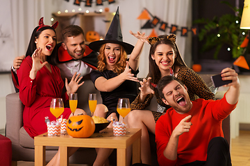 Image showing happy friends in halloween costumes taking selfie