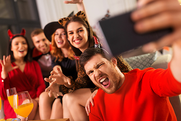 Image showing happy friends in halloween costumes taking selfie