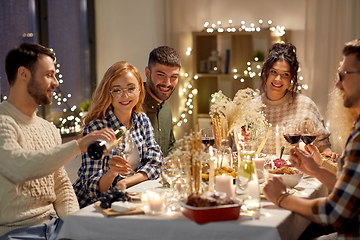 Image showing happy friends with red wine at christmas party