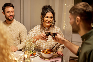 Image showing happy friends drinking red wine at christmas party