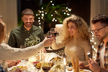 Image showing happy friends drinking red wine at christmas party