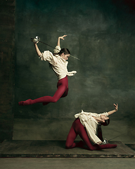 Image showing Two young female ballet dancers like duelists with swords. Ballet and contemporary choreography concept. Creative art photo.