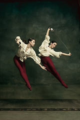 Image showing Two young female ballet dancers like duelists with swords. Ballet and contemporary choreography concept. Creative art photo.