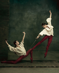 Image showing Two young female ballet dancers like duelists with swords. Ballet and contemporary choreography concept. Creative art photo.