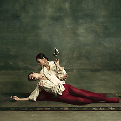 Image showing Two young female ballet dancers like duelists with swords. Ballet and contemporary choreography concept. Creative art photo.