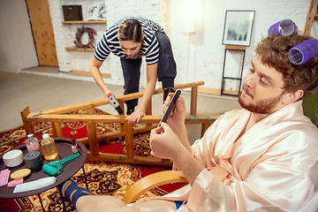 Image showing Gender stereotypes. Wife and husband doing things unusual for their genders in social meanings