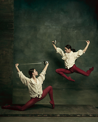 Image showing Two young female ballet dancers like duelists with swords. Ballet and contemporary choreography concept. Creative art photo.