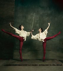 Image showing Two young female ballet dancers like duelists with swords. Ballet and contemporary choreography concept. Creative art photo.