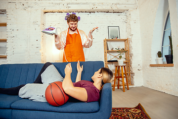 Image showing Gender stereotypes. Wife and husband doing things unusual for their genders in social meanings