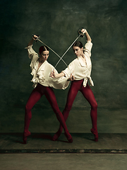 Image showing Two young female ballet dancers like duelists with swords. Ballet and contemporary choreography concept. Creative art photo.