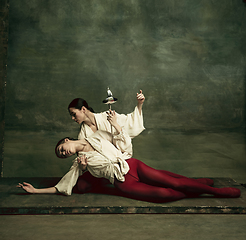 Image showing Two young female ballet dancers like duelists with swords. Ballet and contemporary choreography concept. Creative art photo.