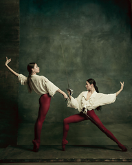 Image showing Two young female ballet dancers like duelists with swords. Ballet and contemporary choreography concept. Creative art photo.