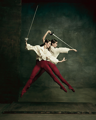 Image showing Two young female ballet dancers like duelists with swords. Ballet and contemporary choreography concept. Creative art photo.