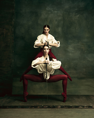 Image showing Two young female ballet dancers like duelists with swords. Ballet and contemporary choreography concept. Creative art photo.