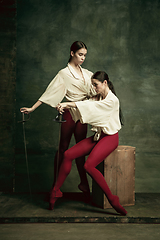 Image showing Two young female ballet dancers like duelists with swords. Ballet and contemporary choreography concept. Creative art photo.