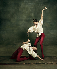 Image showing Two young female ballet dancers like duelists with swords. Ballet and contemporary choreography concept. Creative art photo.