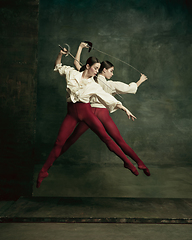 Image showing Two young female ballet dancers like duelists with swords. Ballet and contemporary choreography concept. Creative art photo.