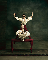 Image showing Two young female ballet dancers like duelists with swords. Ballet and contemporary choreography concept. Creative art photo.