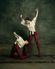 Image showing Two young female ballet dancers like duelists with swords. Ballet and contemporary choreography concept. Creative art photo.