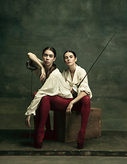 Image showing Two young female ballet dancers like duelists with swords. Ballet and contemporary choreography concept. Creative art photo.