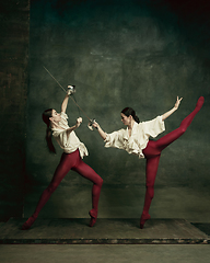 Image showing Two young female ballet dancers like duelists with swords. Ballet and contemporary choreography concept. Creative art photo.