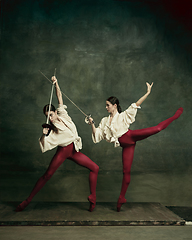 Image showing Two young female ballet dancers like duelists with swords. Ballet and contemporary choreography concept. Creative art photo.