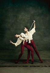 Image showing Two young female ballet dancers like duelists with swords. Ballet and contemporary choreography concept. Creative art photo.