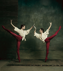 Image showing Two young female ballet dancers like duelists with swords. Ballet and contemporary choreography concept. Creative art photo.