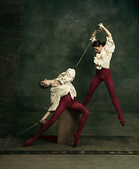 Image showing Two young female ballet dancers like duelists with swords. Ballet and contemporary choreography concept. Creative art photo.