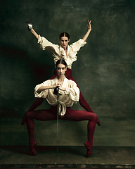 Image showing Two young female ballet dancers like duelists with swords. Ballet and contemporary choreography concept. Creative art photo.