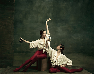 Image showing Two young female ballet dancers like duelists with swords. Ballet and contemporary choreography concept. Creative art photo.