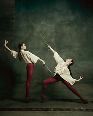 Image showing Two young female ballet dancers like duelists with swords. Ballet and contemporary choreography concept. Creative art photo.