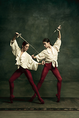 Image showing Two young female ballet dancers like duelists with swords. Ballet and contemporary choreography concept. Creative art photo.