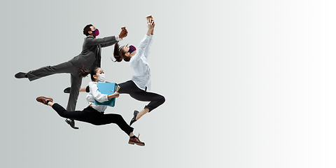 Image showing Happy office workers in face masks jumping and dancing in casual clothes or suit isolated on studio background. Creative collage.