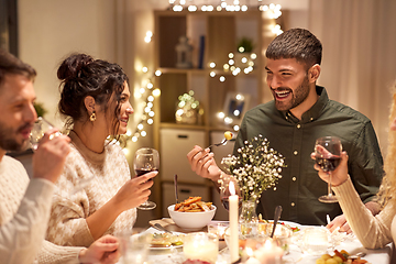 Image showing happy friends having christmas dinner at home