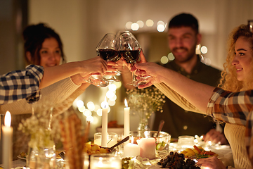 Image showing happy friends drinking red wine at christmas party