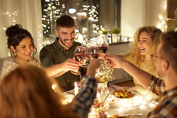 Image showing happy friends drinking red wine at christmas party