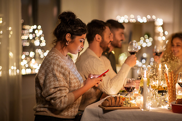 Image showing woman with smartphone at dinner party with friends