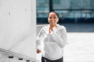 Image showing african american woman running upstairs outdoors