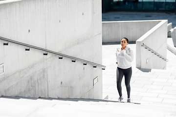 Image showing african american woman running upstairs outdoors