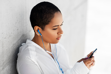 Image showing african american woman with earphones and phone