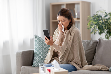 Image showing sick asian woman with smartphone at home