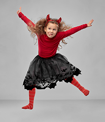 Image showing girl in halloween costume of devil jumping