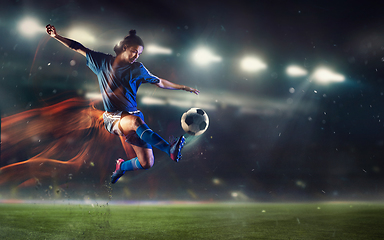 Image showing Young man football player kicking ball during match at stadium. Flyer for ad, design.