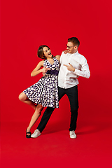Image showing Old-school fashioned young couple dancing isolated on red background