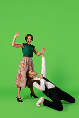 Image showing Old-school fashioned young woman dancing isolated on green background