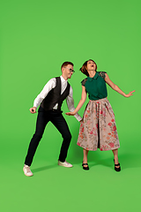 Image showing Old-school fashioned young woman dancing isolated on green background