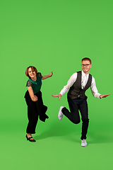 Image showing Old-school fashioned young woman dancing isolated on green background